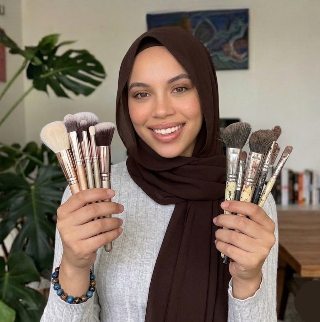Woman holding two sets of makeup brushes in a home setting